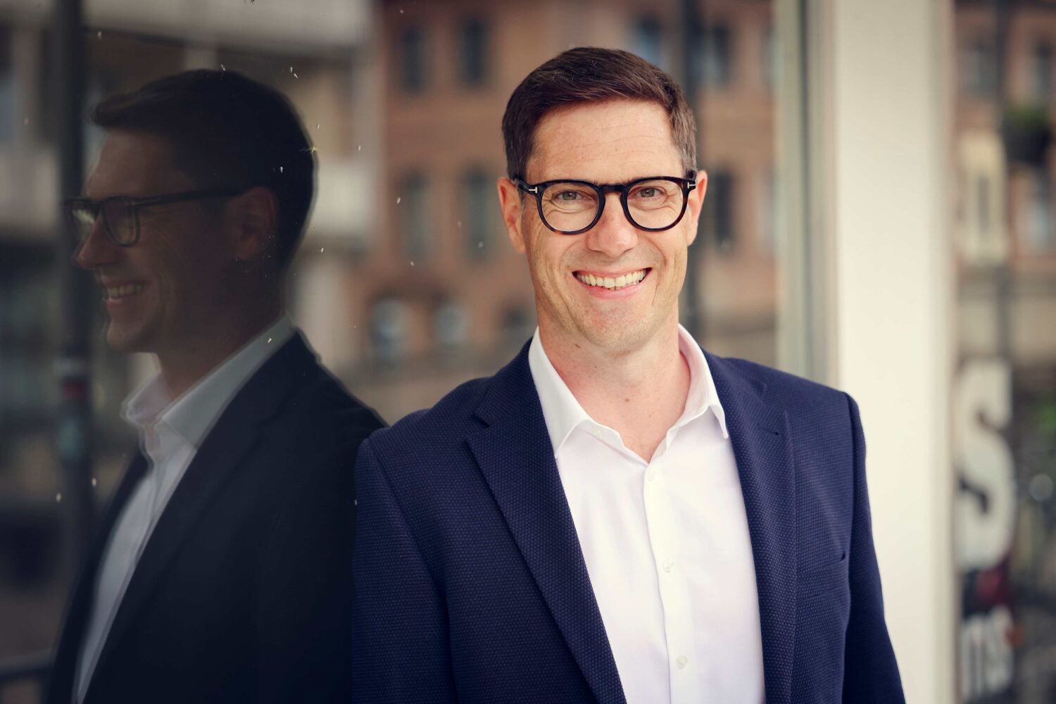 Andreas Dorsch, Interim Manager für Vertrieb, lächelnd vor Bürogebäude