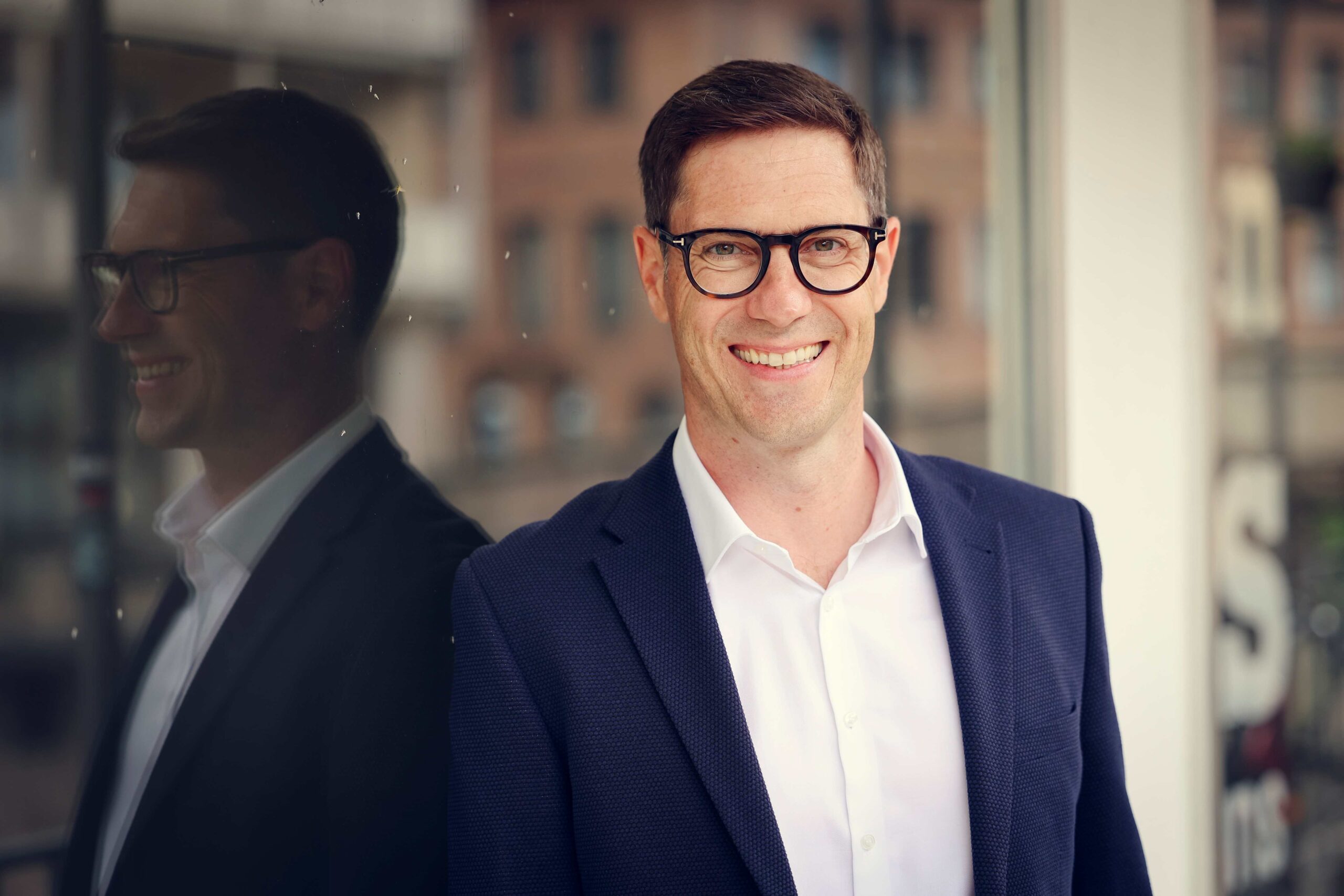 Andreas Dorsch, Interim Manager für Vertrieb, lächelnd vor Bürogebäude